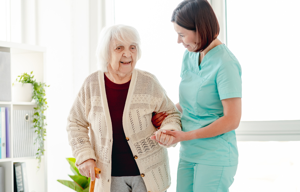 Smiling Caregiver Helping Happy Elderly Woman