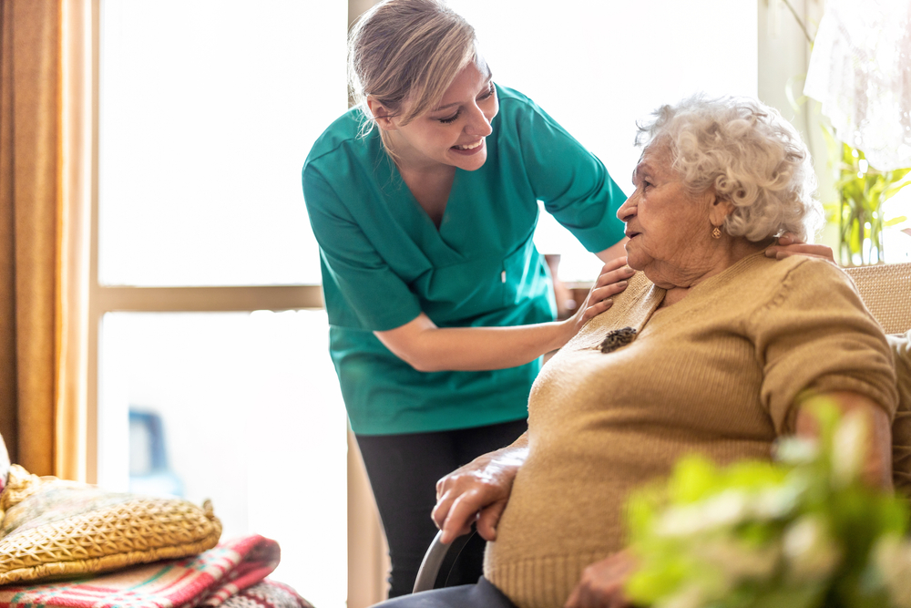 Friendly nurse supporting elderly lady